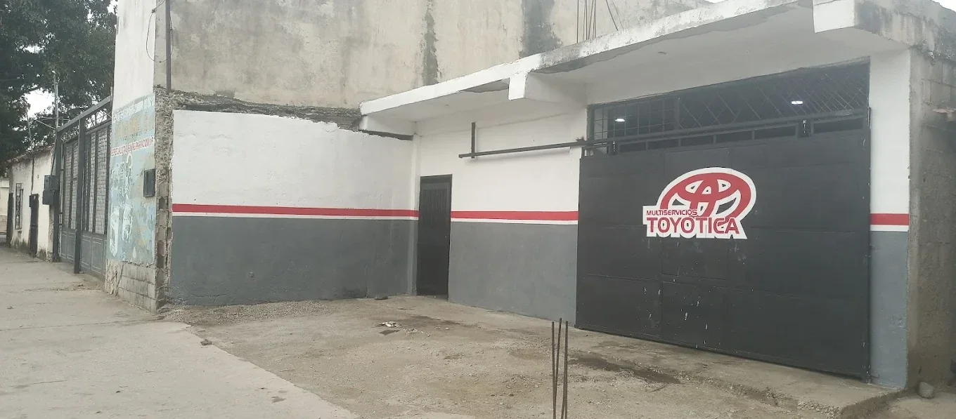 Fachada de Multiservicios Toyotica en la Carrera 13 de Barquisimeto: portón negro con el logo rojo del taller